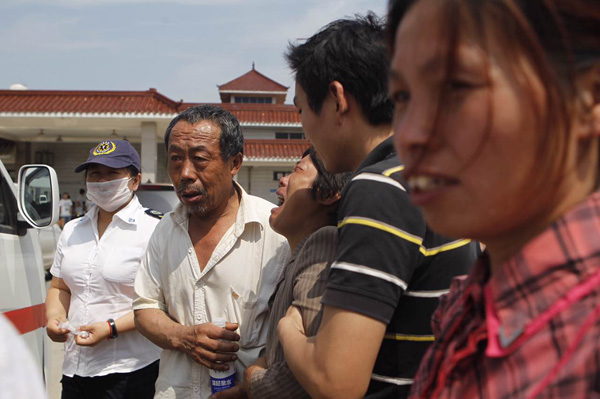 2025-08-02,阜宁县殡仪馆,人群熙攘,奶奶赵玉芩及其他家属站在火化室的门口。 澎湃新闻记者 韦毅 图